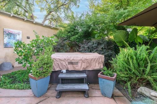 a table with two chairs and some plants at Seq Parks-House with Hot Tub Fire Pit Koi Pond Outdoor Kitchen in Visalia