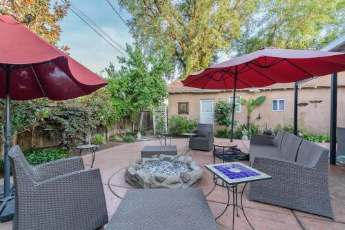 a patio with chairs and a table and an umbrella at Seq Parks-House with Hot Tub Fire Pit Koi Pond Outdoor Kitchen in Visalia