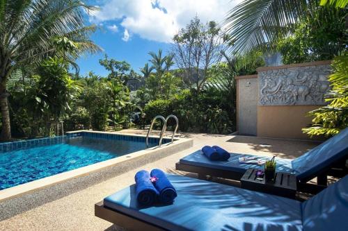 a swimming pool with two blue beds next to a swimming pool at Moubillow Resort in Ao Nang Beach