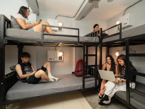 a group of people sitting on bunk beds at OH Hostels - Bangkok in Bangkok