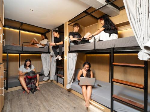 a group of people sitting in bunk beds at OH Hostels - Bangkok in Bangkok