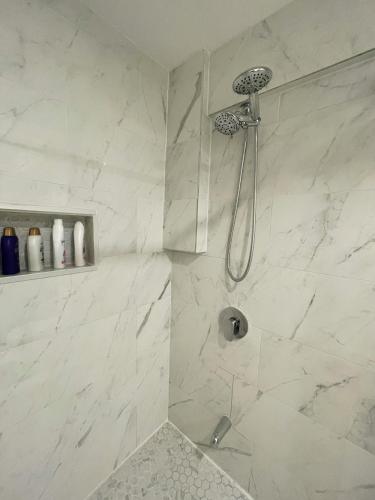 ein Badezimmer mit Dusche und weißen Marmorwänden in der Unterkunft New Cosy bright and Spacious Apartment in East Gwillimbury