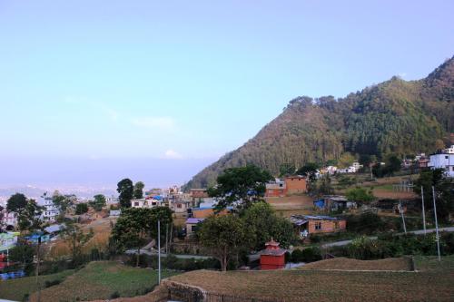 a town on a hill with mountains in the background at Beautiful house and garden in Kathmandu