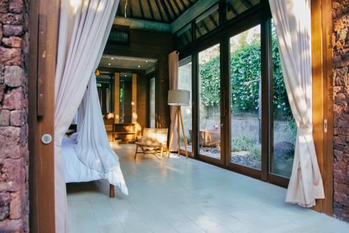 an open doorway to a living room with glass doors at Ruby Romance Oceanside Villas in Tejakula