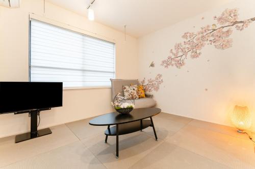 a living room with a tv and a chair and a table at Omotenashi HOTEL Asakusa in Tokyo