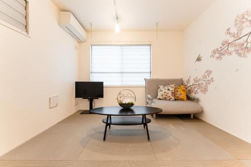 a living room with a table and a couch at Omotenashi HOTEL Asakusa in Tokyo