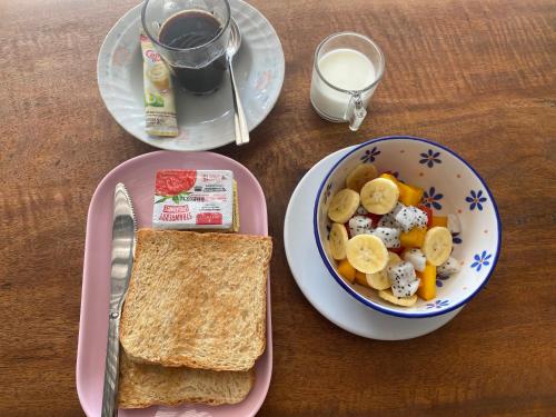 un tavolo con una ciotola di cibo e un piatto di pane tostato di Arya Bungalow a Phra Ae beach