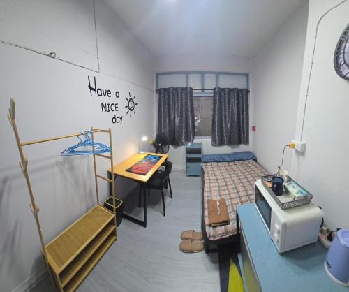 a small room with a bed and a table and a desk at 104 Peaceful and Cosy apartment with cool fan near BTS with free WiFi in Bangkok