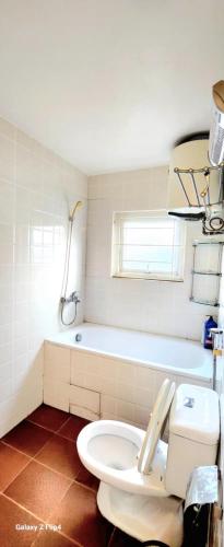 a bathroom with a toilet and a bath tub at Nhà riêng 3 phòng ngủ 6 giường in Hanoi