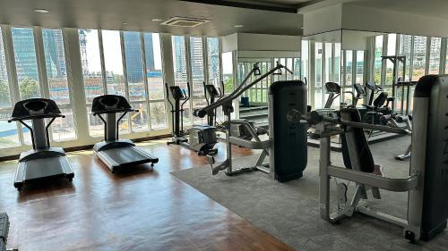 un gimnasio con equipo cardiovascular en un edificio con ventanas en Tri Tower Residence 走路3分钟到新加坡马来西亚海关15分钟到新加坡 Walk 3 Minutes to CIQ, 15 Minutes to Singapore, en Johor Bahru