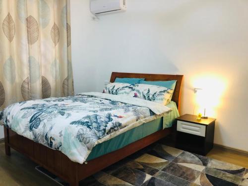 a bedroom with a bed and a night stand with a lamp at Family Transit Home Unit 8 G4 in Port Moresby