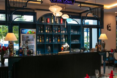 a bar with a lot of bottles of alcohol at Silk River Hoi An Hotel & Spa in Hoi An