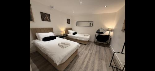 um quarto de hotel com duas camas e uma escrivaninha em Kings Lodge By Nivaas 1 em Reading