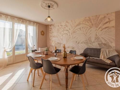 a dining room with a table and chairs and a couch at Gîte confortable au cœur du vignoble avec Wifi et parking, proche du Puy du Fou - FR-1-622-94 in Rablay-sur-Layon