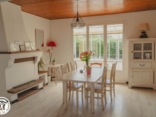 une salle à manger avec une table et une cheminée dans l'établissement Gîte avec jeux et terrasse à La Guittière - FR-1-426-567, à Saint-Hilaire-de-Talmont