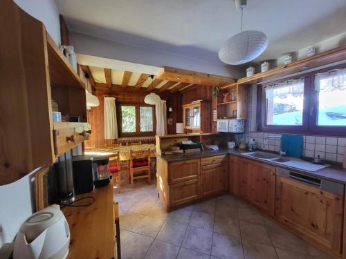 une grande cuisine avec des placards en bois et une grande fenêtre dans l'établissement Chalet spacieux avec cheminée et salle de cinéma à Montgenèvre - FR-1-266-242, à Montgenèvre