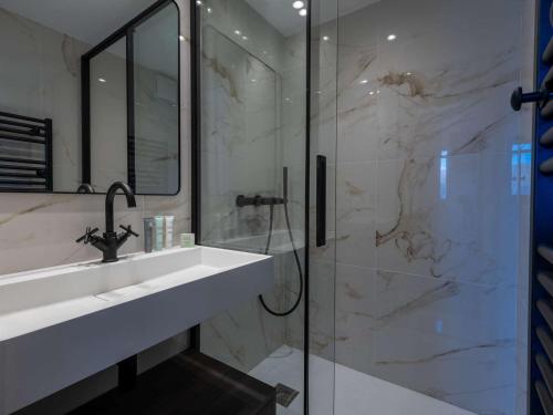 une salle de bain avec un lavabo et une douche en verre dans l'établissement Courchevel 1850 - Appart. 4 pers. - Ski aux pieds, Cheminée, WIFI, Parking - FR-1-631-223, à Courchevel