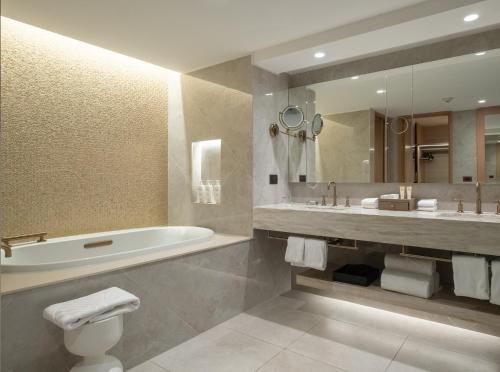 a bathroom with a tub and a toilet and a sink at Mandarin Oriental, Santiago in Santiago
