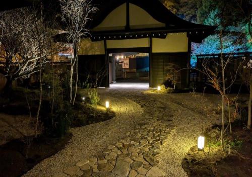 a pathway leading to a building at night at Kinzan Villa in Izu