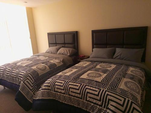 Apartment in La Paz #07 في لاباز: سريرين يجلسون بجانب بعض في غرفة النوم