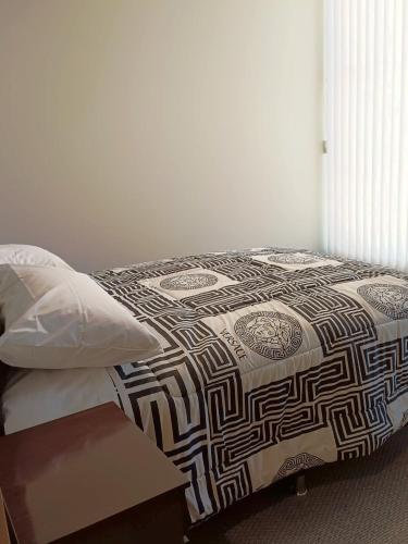 a bed with a comforter and pillows in a room at Apartment in La Paz #07 in La Paz
