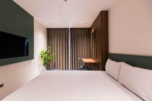 a bedroom with a large white bed and a television at Luxe Paradise Suites Hotel Hoang Cau in Hanoi