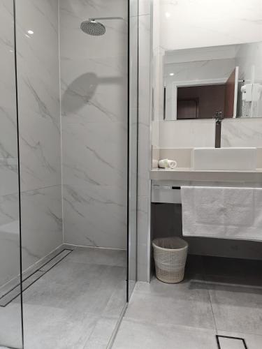 a bathroom with a glass shower and a sink at St Georges Motor Inn in Melbourne