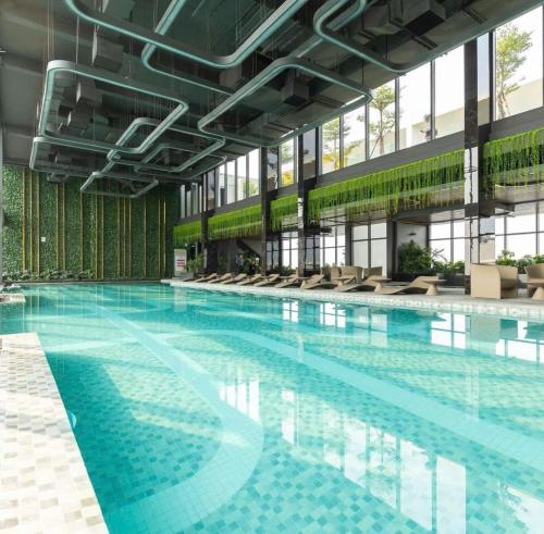 a large swimming pool with chairs in a building at Vinhomes Smart City Tây Mỗ Nam Từ Liêm in Hanoi