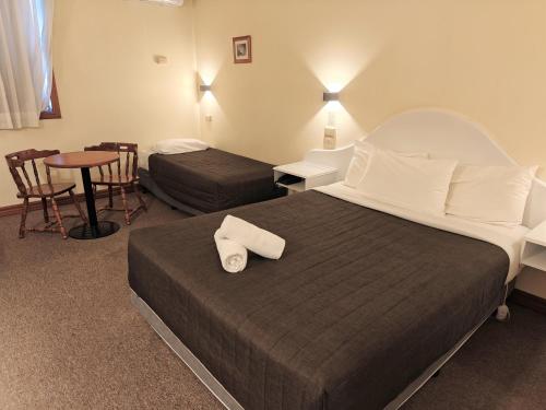 a hotel room with a bed and a table and chairs at St Georges Motor Inn in Melbourne