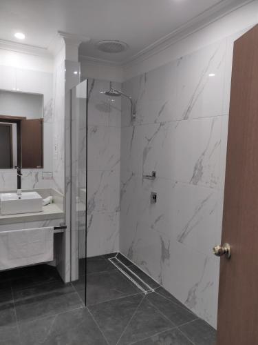 a bathroom with a shower and a sink at St Georges Motor Inn in Melbourne