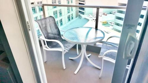 a glass table and chairs on a balcony at ~Four-star serviced apartment in Honolulu