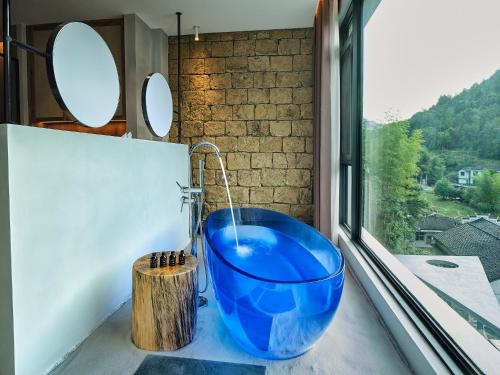 张家界Zhangjiajie Juanjie Luxury Resorts--Provide free one-way airport pick-up service的一间带蓝色碗水槽和窗户的浴室