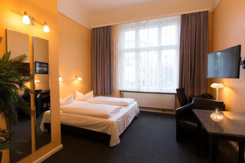 a hotel room with two beds and a mirror at Hotel am Hermannplatz in Berlin