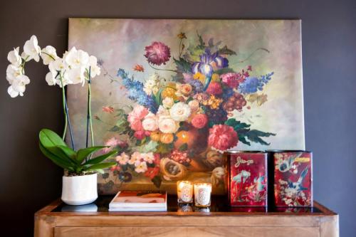 a painting of flowers on top of a wooden table at CasaVostra - Ambience Suites in Ostra Vetere