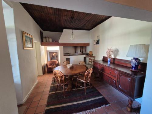 a dining room with a wooden table and chairs at Authentic Farmstyle Stay in Aloe Valley in Albertinia