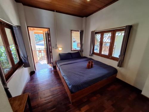 a bedroom with a bed in a room with windows at Sleep Pai Bed & Breakfast in Pai