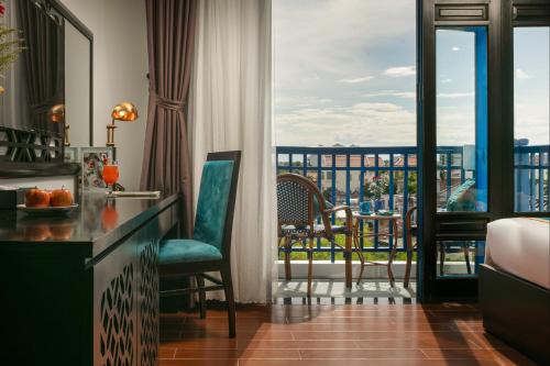 a hotel room with a view of a balcony at Silk River Hoi An Hotel & Spa in Hoi An