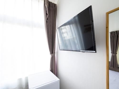 a flat screen tv hanging on a wall at HOTEL THE CUBE Naha Kokusai Street in Naha
