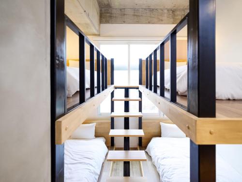 a room with two bunk beds and a staircase at HOTEL THE CUBE Naha Kokusai Street in Naha