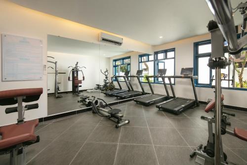 a gym with several treadmills and elliptical machines at Silk River Hoi An Hotel & Spa in Hoi An