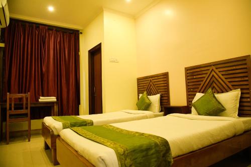 a hotel room with two beds and a window at Prabash Atithi Griha in Guwahati