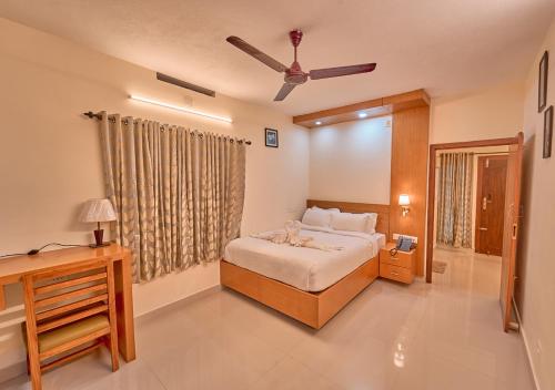 a bedroom with a bed and a ceiling fan at Ushasree Wayanad Pool Resort by VOYE HOMES in Ambalavayal