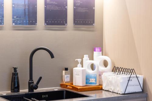 a kitchen counter with a sink and bottles of soap at Atour Hotel Central China Normal University Wuhan Street Entrance in Wuhan
