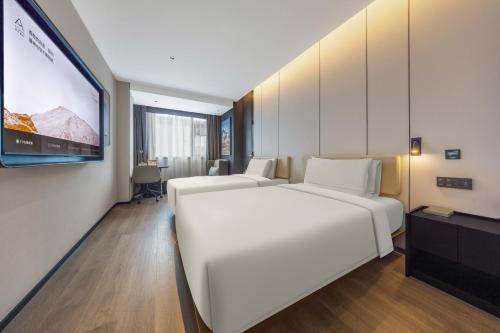 Habitación de hotel con 2 camas y pantalla de proyección en Atour Hotel Central China Normal University Wuhan Street Entrance, en Wuhan