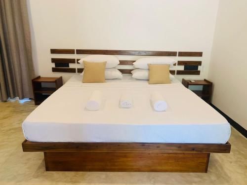 a bedroom with a large bed with white sheets and pillows at Wave Crest Villa in Dickwella