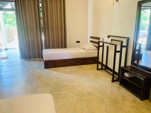a bedroom with a bed and a television in it at Wave Crest Villa in Dickwella