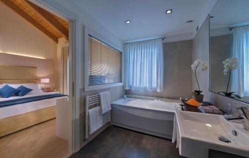 a large bathroom with a tub and a bed at Annia Park Hotel Venice Airport in Tessera