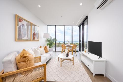 a living room with a white couch and a table at Luxury Bay View Apartment in Melbourne