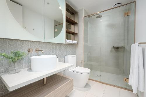 a bathroom with a toilet and a sink and a shower at Luxury Bay View Apartment in Melbourne