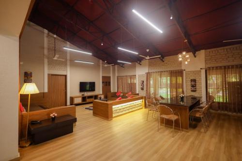 una sala de estar con un sofá y una mesa en Tiki Farms, en Karjat